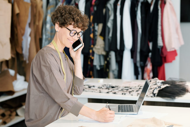 Pretty young owner of fashion designing studio consulting clients